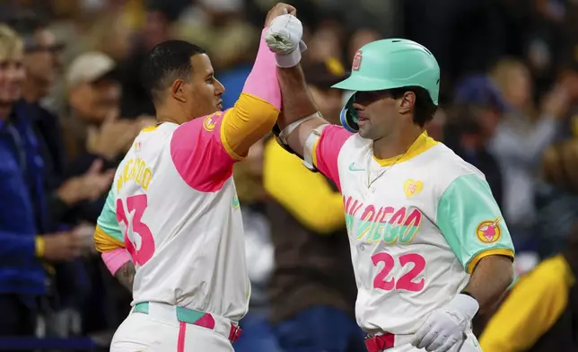 San Diego Padres' Graham Pauley, right, celebrates with Manny Machado after hitting a two-run home run during the seventh inning of a baseball game against the Philadelphia Phillies, Friday, April 26, 2024, in San Diego. (AP Photo/Brandon Sloter)
