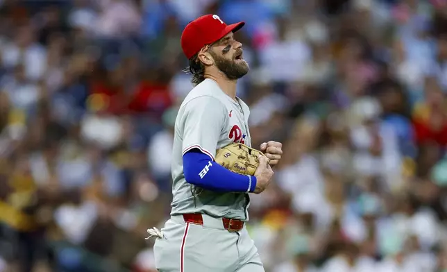Philadelphia Phillies first basemen Bryce Harper reacts after a collision at first with San Diego Padres' Jurickson Profar during the second inning of a baseball game, Friday, April 26, 2024, in San Diego. (AP Photo/Brandon Sloter)