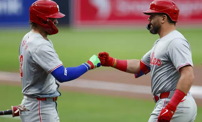 Philadelphia Phillies' Kyle Schwarber, right, celebrates with Bryce Harper (3) after hitting a solo home run during the first inning of a baseball game against the San Diego Padres, Friday, April 26, 2024, in San Diego. (AP Photo/Brandon Sloter)