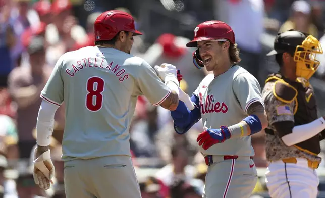 Philadelphia Phillies' Bryson Stott, center, celebrates after his two-run home run with teammate Nick Castellanos (8) during the fourth inning of a baseball game against the San Diego Padres, Sunday, April 28, 2024, in San Diego. (AP Photo/Brandon Sloter)