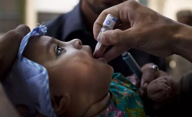 FILE - A child is administered a polio vaccination by a district health team worker outside a children's hospital in Peshawar, Pakistan on Wednesday, May 30, 2012. (AP Photo/Anja Niedringhaus, File)