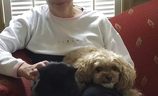 This Jan. 28, 2017 photo provided by Rod Azama shows his wife Susan relaxing with her dog Sunny at home in Silver Spring, Md. Eight states and Washington D.C. allow physician-assisted death for certain terminally ill patients, like Susan Azama., but only for their own residents. Vermont and Oregon permit any qualifying American to travel to their state for the practice, so the Maryland resident traveled to Oregon. (Rod Azama via AP)