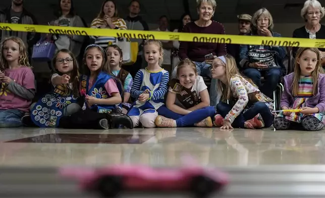 Girl Scout Daisys watch a car race during the Girl Scouts Pinewood Derby, Saturday, April 13, 2024, in Marietta, Ga. (AP Photo/Mike Stewart)