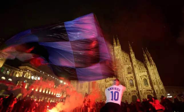 Inter Milan fans celebrate in Piazza Duomo square in front of the gothic cathedral after Inter Milan won the Serie A title against AC Milan in Milan, Italy, Monday, April 22, 2024. (AP Photo/Antonio Calanni)