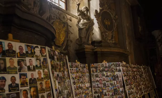 Photographs of Ukrainian soldiers killed during the Russian Ukrainian war are displayed in the Saints Peter and Paul church in Lviv, Ukraine, April 16, 2024. (AP Photo/Francisco Seco)