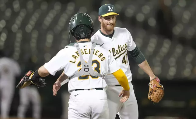 Oakland Athletics catcher Shea Langeliers, left, celebrates with pitcher Michael Kelly after the Athletics defeated the Pittsburgh Pirates in a baseball game in Oakland, Calif., Monday, April 29, 2024. (AP Photo/Jeff Chiu)