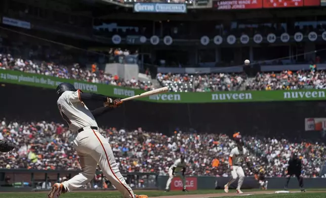 San Francisco Giants' LaMonte Wade Jr. hits a sacrifice fly against the Pittsburgh Pirates during the third inning of a baseball game Sunday, April 28, 2024, in San Francisco. (AP Photo/Godofredo A. Vásquez)