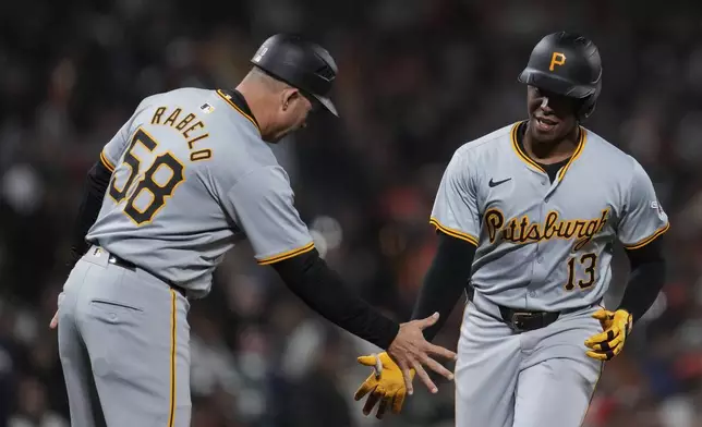 Pittsburgh Pirates' Ke'Bryan Hayes, right, celebrates with third base coach and field coordinator Mike Rabelo, left, after hitting a solo home run against the San Francisco Giants during the 10th inning of a baseball game Saturday, April 27, 2024, in San Francisco. (AP Photo/Godofredo A. Vásquez)