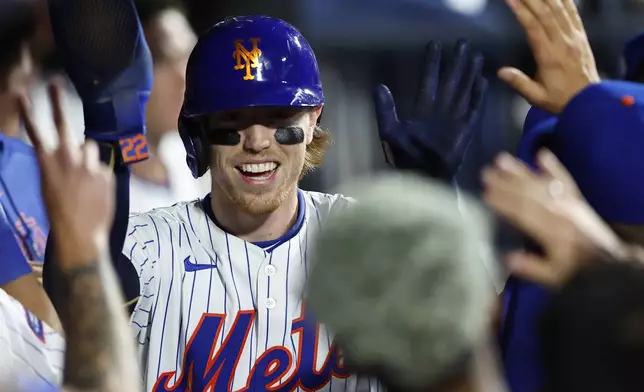 New York Mets' Brett Baty celebrates in the dugout after scoring against the Pittsburgh Pirates during the sixth inning of a baseball game, Monday, April 15, 2024, in New York. (AP Photo/Noah K. Murray)