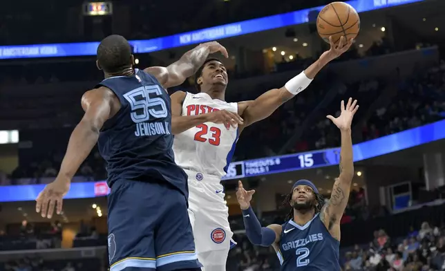 Detroit Pistons guard Jaden Ivey (23) shoots between Memphis Grizzlies center Trey Jemison (55) and guard Zavier Simpson (2) in the first half of an NBA basketball game Friday, April 5, 2024, in Memphis, Tenn. (AP Photo/Brandon Dill)