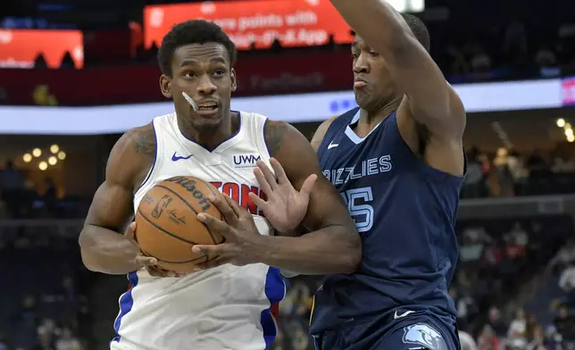 Detroit Pistons center Jalen Duren handles the ball against Memphis Grizzlies center Trey Jemison (55) in the first half of an NBA basketball game Friday, April 5, 2024, in Memphis, Tenn. (AP Photo/Brandon Dill)