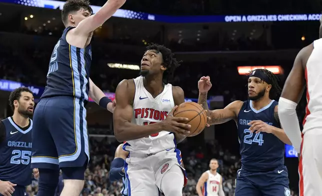 Detroit Pistons forward Tosan Evbuomwan, center, looks to shoot between Memphis Grizzlies forwards Jake LaRavia (3) and Lamar Stevens (24) in the second half of an NBA basketball game Friday, April 5, 2024, in Memphis, Tenn. (AP Photo/Brandon Dill)