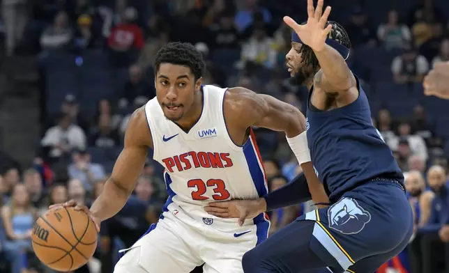 Detroit Pistons guard Jaden Ivey (23) handles the ball against Memphis Grizzlies forward Lamar Stevens in the first half of an NBA basketball game Friday, April 5, 2024, in Memphis, Tenn. (AP Photo/Brandon Dill)