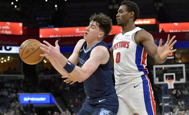 Memphis Grizzlies guard Luke Kennard, left, handles the ball against Detroit Pistons center Jalen Duren (0) in the first half of an NBA basketball game Friday, April 5, 2024, in Memphis, Tenn. (AP Photo/Brandon Dill)