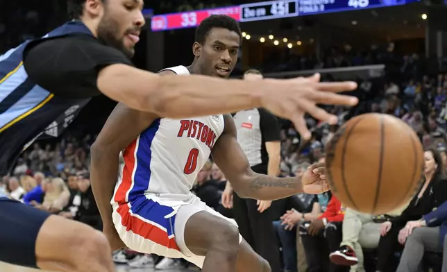 Detroit Pistons center Jalen Duren (0) and Memphis Grizzlies forward Maozinha Pereira, left, reach for the ball in the first half of an NBA basketball game Friday, April 5, 2024, in Memphis, Tenn. (AP Photo/Brandon Dill)