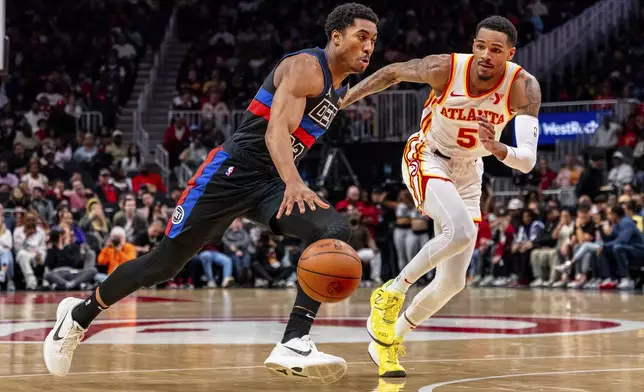 Detroit Pistons guard Jaden Ivey (23) dribbles the ball while guarded by Atlanta Hawks guard Dejounte Murray (5) during the first half of an NBA basketball game, Wednesday, April 3, 2024, in Atlanta. (AP Photo/Jason Allen)