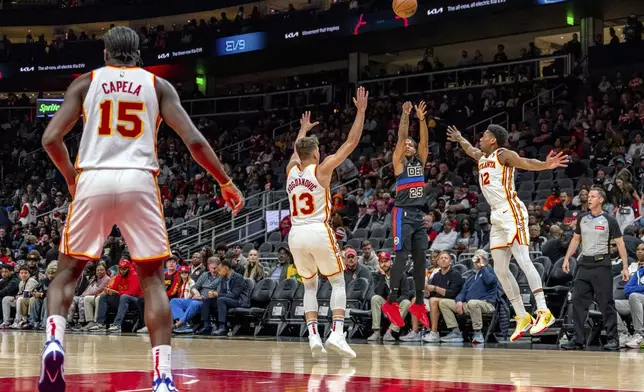 Detroit Pistons guard Marcus Sasser (25) shoots a three-pointer against Atlanta Hawks guard Bogdan Bogdanovic (13) and Atlanta Hawks forward De'Andre Hunter (12) during the first half of an NBA basketball game, Wednesday, April 3, 2024, in Atlanta. (AP Photo/Jason Allen)