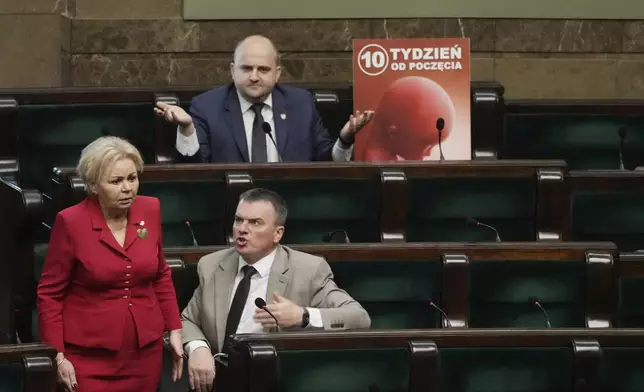 Dariusz Matecki, a conservative lawmaker in the Polish parliament, displays a poster showing a fetus and the words "10th week after conception," during a debate on liberalizing the abortion law , in Warsaw, Poland, on Thursday April 11, 2024. He also played the sound of a child's heartbeat through a microphone next to his chair. The traditionally Catholic nation has one of the most restrictive laws in Europe — but the reality is that many women terminate pregnancies at home with pills mailed from abroad. (AP Photo/Czarek Sokolowski)