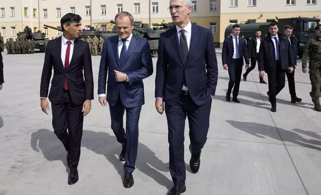 Britain's Prime Minister Rishi Sunak, left, Poland's Prime Minister Donald Tusk and NATO Secretary General Jens Stoltenberg arrive together at the Armourd Brigade barracks in Warsaw, Poland, Tuesday, April 23, 2024.(AP Photo/Alastair Grant, Pool)