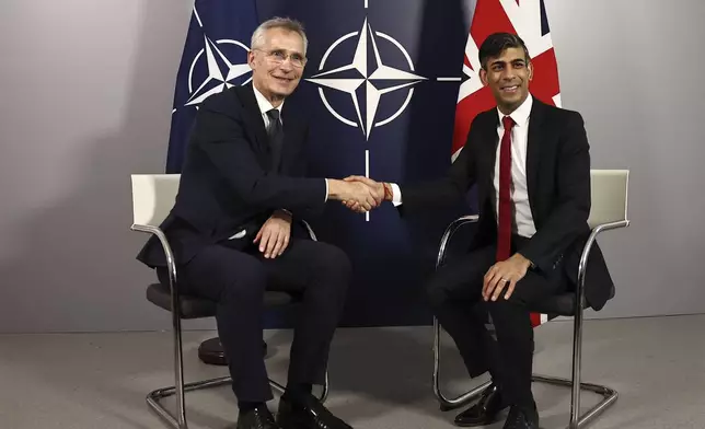 NATO Secretary General Jens Stoltenberg, left, and Britain's Prime Minister Rishi Sunak shake hands prior to talks at the Warsaw Armoured Brigade in Warsaw, Poland, Tuesday April 23, 2024. (Henry Nicholls/Pool via AP)