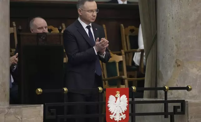 Poland's President Andrzej Duda applauds in the Polish parliament in Warsaw, Poland, Thursday, 25 April 2024, after a policy speech in which Foreign Minister Radek Sikorski said Poland wants to return to the group of countries that sets the agenda for the European Union. (AP Photo/Czarek Sokolowski)