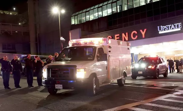 Transport ambulances carry the bodies of two slain officers to the Wally Howard Forensics Science Center in Syracuse, N.Y. early Monday morning, April 15, 2024. Police officers from several local agencies gathered at Upstate hospital's emergency room to hear the news of two slain officers. (Dennis Nett/The Post-Standard via AP)