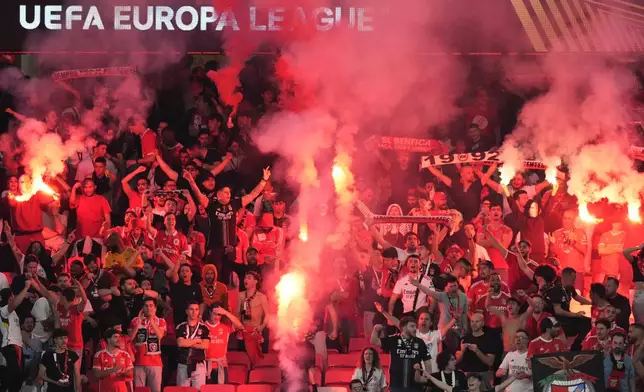 Benfica supporters light flares at the stand during the Europa League quarterfinals, first leg, soccer match between SL Benfica and Olympique de Marseille at the Luz stadium in Lisbon, Thursday, April 11, 2024. (AP Photo/Armando Franca)