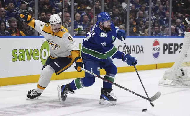 Vancouver Canucks' Filip Hronek (17) shoots the puck down the ice away from Nashville Predators' Filip Forsberg (9) during the second period in Game 1 of an NHL hockey Stanley Cup first-round playoff series in Vancouver, British Columbia, on Sunday, April 21, 2024. (Darryl Dyck/The Canadian Press via AP)