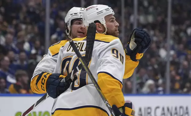Nashville Predators' Ryan O'Reilly (90) and Luke Evangelista celebrate O'Reilly's goal against the Vancouver Canucks during the second period in Game 1 of an NHL hockey Stanley Cup first-round playoff series in Vancouver, British Columbia, on Sunday, April 21, 2024. (Darryl Dyck/The Canadian Press via AP)