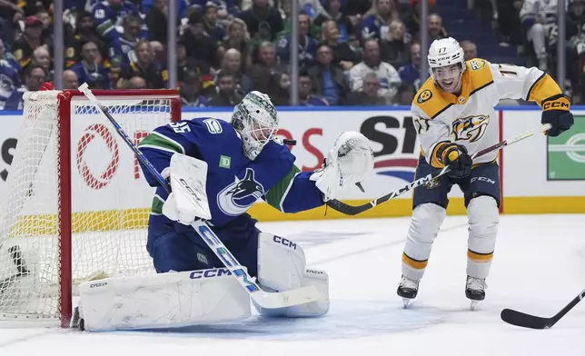 Nashville Predators' Luke Evangelista, right, watches as teammate Ryan O'Reilly, not seen, scores against Vancouver Canucks goalie Thatcher Demko during the second period in Game 1 of an NHL hockey Stanley Cup first-round playoff series in Vancouver, British Columbia, on Sunday, April 21, 2024. (Darryl Dyck/The Canadian Press via AP)