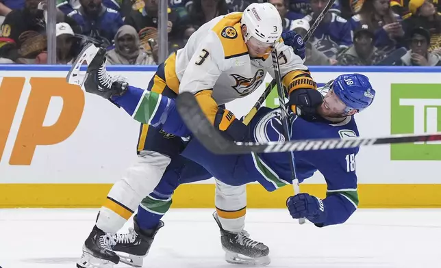 Nashville Predators' Jeremy Lauzon, left, checks Vancouver Canucks' Sam Lafferty during the third period in Game 2 of an NHL hockey Stanley Cup first-round playoff series Tuesday, April 23, 2024, in Vancouver, British Columbia. (Darryl Dyck/The Canadian Press via AP)