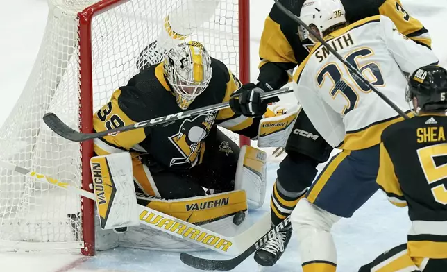 Pittsburgh Penguins goaltender Alex Nedeljkovic (39) makes a save against Nashville Predators' Cole Smith (36) during the first period of an NHL hockey game, Monday, April 15, 2024, in Pittsburgh. (AP Photo/Matt Freed)