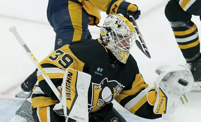 Pittsburgh Penguins goaltender Alex Nedeljkovic (39) makes a save in front of Nashville Predators' Luke Evangelista (77) during the first period of an NHL hockey game, Monday, April 15, 2024, in Pittsburgh. (AP Photo/Matt Freed)