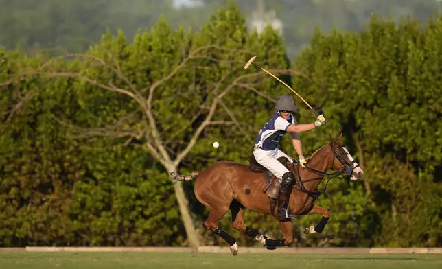 Britain's Prince Harry plays a ball during the 2024 Royal Salute Polo Challenge to Benefit Sentebale, Friday, April 12, 2024, in Wellington, Fla. Prince Harry, co-founding patron of the Sentebale charity, will play on the Royal Salute Sentebale Team. (AP Photo/Rebecca Blackwell)