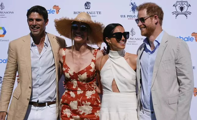 Britain's Prince Harry, right, and wife Meghan Markle, Duchess of Sussex, second right, pose for photos with Argentine professional polo player Ignacio "Nacho" Figueras, left, and his wife Delfina Blaquier as they arrive for the 2024 Royal Salute Polo Challenge to Benefit Sentebale, Friday, April 12, 2024, in Wellington, Fla. Prince Harry, co-founding patron of the Sentebale charity, will play on the Royal Salute Sentebale Team. (AP Photo/Rebecca Blackwell)