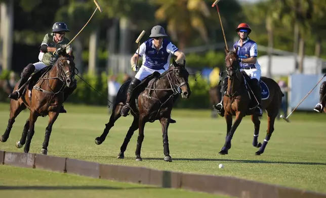 Britain's Prince Harry, center, races for a ball as he plays in the 2024 Royal Salute Polo Challenge to Benefit Sentebale, Friday, April 12, 2024, in Wellington, Fla. Prince Harry, co-founding patron of the Sentebale charity, will play on the Royal Salute Sentebale Team. (AP Photo/Rebecca Blackwell)