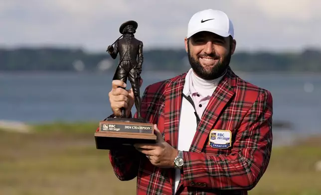 Scottie Scheffler holds the trophy after winning the weather delayed RBC Heritage golf tournament, Monday, April 22, 2024, in Hilton Head Island, S.C. (AP Photo/Chris Carlson)