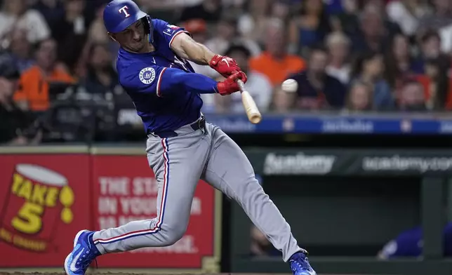 Texas Rangers designated hitter Wyatt Langford hits a two-run double against the Houston Astros during the third inning of a baseball game Friday, April 12, 2024, in Houston. (AP Photo/Kevin M. Cox)