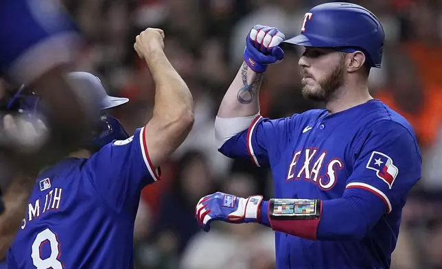 Texas Rangers' Jonah Heim, right, celebrates with Josh Smith (8) after hitting a three-run home run during the third inning of the team's baseball game against the Houston Astros on Friday, April 12, 2024, in Houston. (AP Photo/Kevin M. Cox)