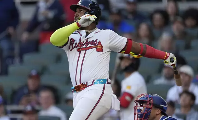 Atlanta Braves designated hitter Marcell Ozuna (20) follows through on a three-run home run as Texas Rangers catcher Andrew Knizner (12) looks on in the first inning of a baseball game Sunday, April 21, 2024, in Atlanta. (AP Photo/John Bazemore)
