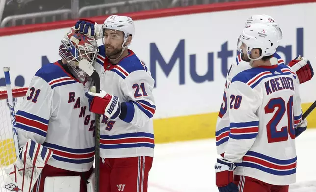 New York Rangers goaltender Igor Shesterkin (31) is embraced by teammate Barclay Goodrow (21) after defeating the Washington Capitals in Game 3 of an NHL hockey Stanley Cup first-round playoff series, Friday, April 26, 2024, in Washington. (AP Photo/Tom Brenner)