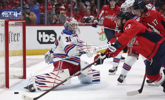 New York Rangers goaltender Igor Shesterkin (31) makes a save as Washington Capitals right wing Tom Wilson (43) shoots during the first period in Game 4 of an NHL hockey Stanley Cup first-round playoff series Sunday, April 28, 2024, in Washington. (AP Photo/Tom Brenner)