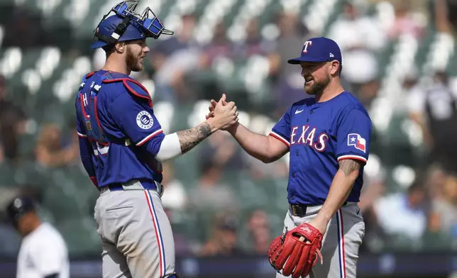 Texas Rangers catcher Jonah Heim, left, and pitcher Kirby Yates (39) celebrate after a baseball game against the Detroit Tigers, Thursday, April 18, 2024, in Detroit. (AP Photo/Paul Sancya)