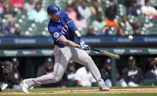 Texas Rangers' Jonah Heim hits a two-run single against the Detroit Tigers in the sixth inning of a baseball game, Wednesday, April 17, 2024, in Detroit. (AP Photo/Paul Sancya)