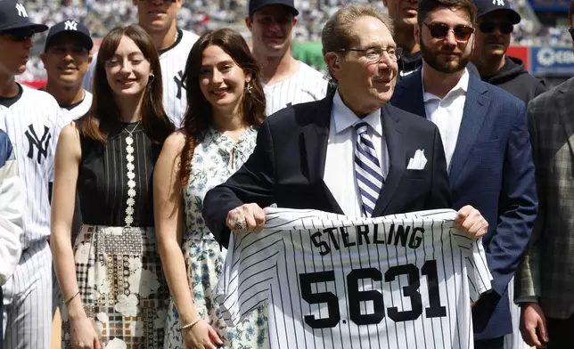 New York Yankees broadcaster John Sterling holds a jersey that has the number of games he broadcasted during a retirement ceremony before a baseball game agains the Tampa Bay Rays at Yankee Stadium in New York, Saturday, April 20, 2024 (AP Photo/Noah K. Murray)