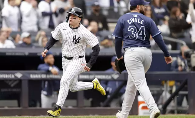 New York Yankees' Alex Verdugo, left, comes around to score past Tampa Bay Rays pitcher Aaron Civale (34) during the fifth inning of a baseball game Sunday, April 21, 2024, in New York. (AP Photo/Adam Hunger)
