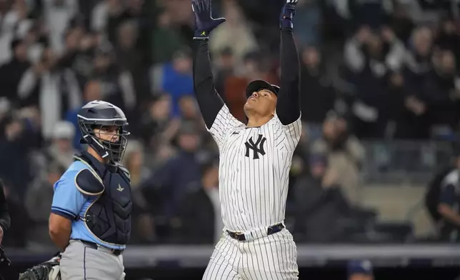 New York Yankees' Juan Soto, right, celebrates as he reaches home plate after hitting a three-run home run during the seventh inning of a baseball game as Tampa Bay Rays catcher Ben Rortvedt watches Friday, April 19, 2024, in New York. (AP Photo/Frank Franklin II)