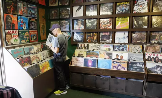 Michael Iffland checks out some Beatles vinyl at Tracks In Wax record shop, Thursday, April 18, 2024, in Phoenix. Special LP releases, live performances and at least one giant block party are scheduled around the U.S. Saturday as hundreds of shops celebrate Record Store Day amid a surge of interest in vinyl and the day after the release of Taylor Swift's latest album. (AP Photo/Ross D. Franklin)