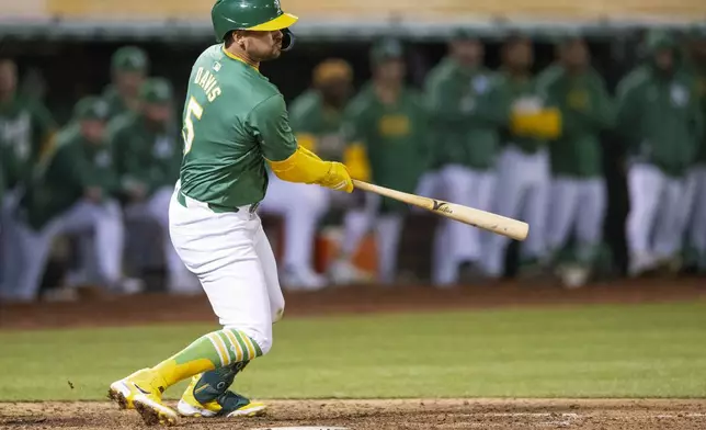 Oakland Athletics third baseman J.D. Davis hits a single during the tenth inning of a baseball game against the Boston Red Sox, Tuesday, April 2, 2024, in Oakland, Calif. (AP Photo/Nic Coury)