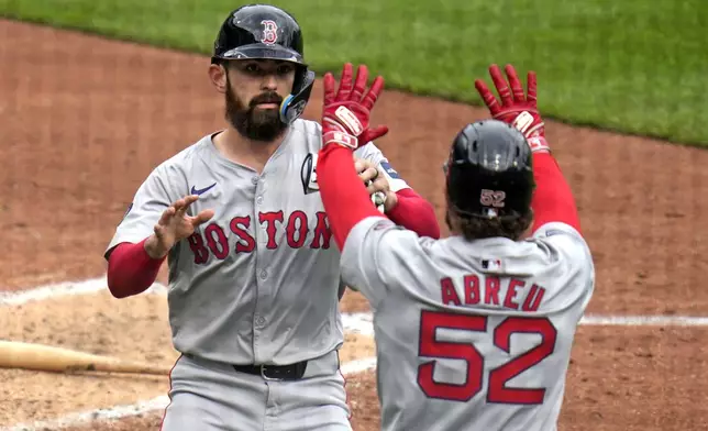Boston Red Sox's Connor Wong, left, celebrates with Wilyer Abreu (52) after they scored on a single by teammate Reese McGuire off Pittsburgh Pirates relief pitcher Ryder Ryan during the fifth inning of a baseball game in Pittsburgh, Sunday, April 21, 2024. (AP Photo/Gene J. Puskar)